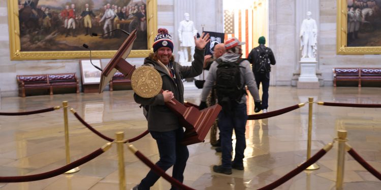 sustinatorii-lui-trump-incep-sa-fie-identificati:-unul-a-fost-concediat-deja.-cine-este-barbatul-care-cara-un-pupitru-in-congres